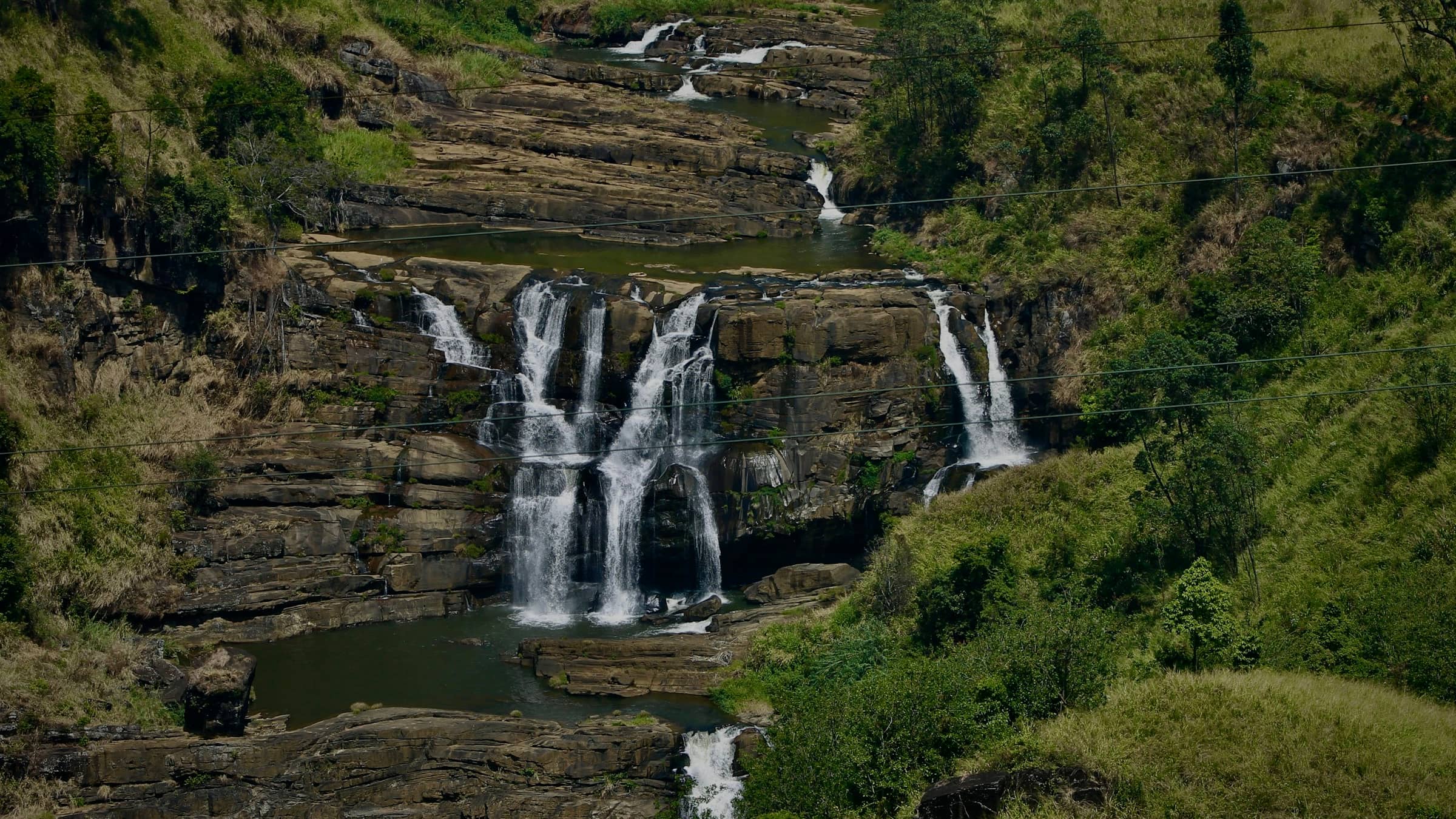 St Clair’s Falls dropping in two wide curtains through hill-country forest.